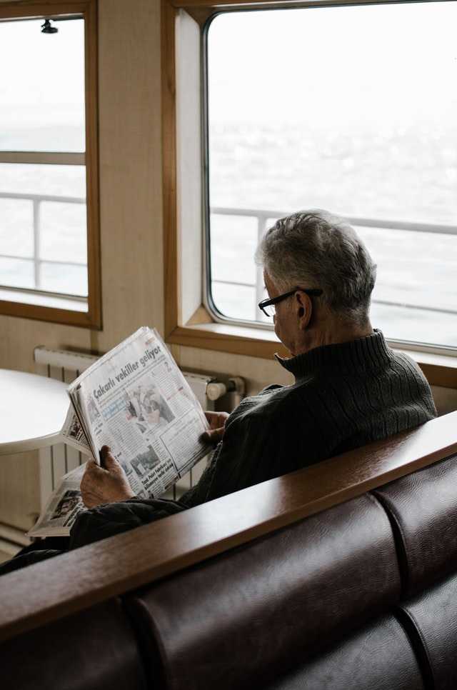 single old man reading newspaper